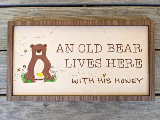 An old bear lives here with his honey sign